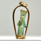 Ancient Egyptian blue-green faience amulet depicting a stylized standing divine figure, mounted in a later gold pendant setting, circa 664–30 BCE.