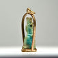 Late Period to Ptolemaic Egyptian amulet showing a standing protective or funerary figure with worn blue-green glaze and gold setting.