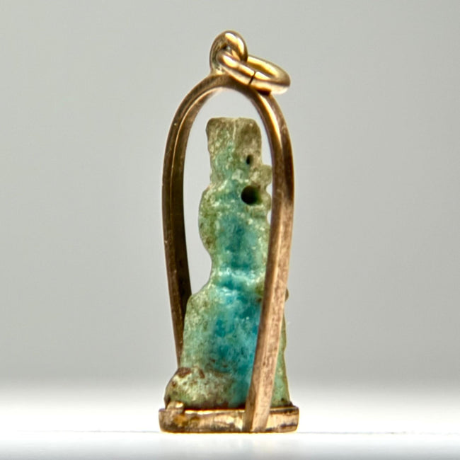 Ancient Egyptian faience pendant amulet with stylized divine figure, original suspension perforation, and later gold frame.