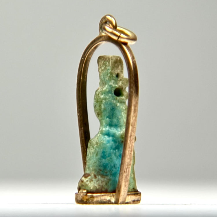 Ancient Egyptian faience pendant amulet with stylized divine figure, original suspension perforation, and later gold frame.