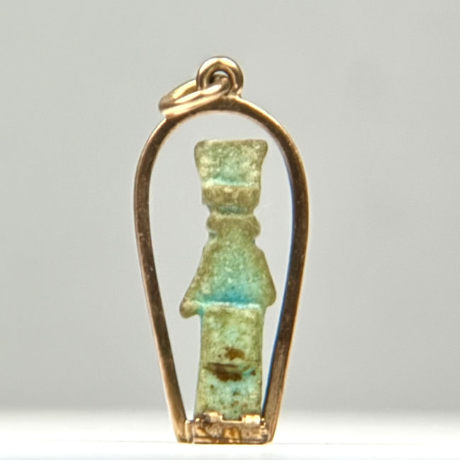 Blue-green Ancient Egyptian faience amulet with columnar body, projecting arms, distinctive headdress, and age-related surface accretions.
