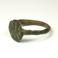Profile view of Byzantine bronze ring showing integral bezel, slender band, and incised shoulder decoration