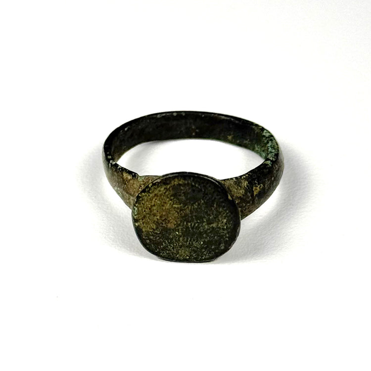 Ancient Roman-Byzantine bronze ring viewed from the side, showing broad shoulders, worn bezel, and naturally aged green patina