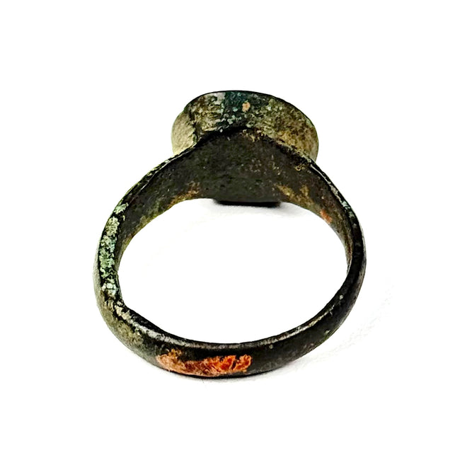 Rear angled view of Eastern Mediterranean bronze finger ring with intact hoop, surface oxidation, and archaeological wear