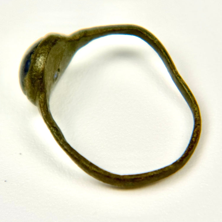 Angled view of ancient Roman bronze ring with blue cabochon and naturally aged patina