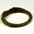 Side view of ancient Roman bronze finger ring with broad shoulders and aged green-brown patina