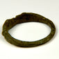 Side view of ancient Roman bronze finger ring with broad shoulders and aged green-brown patina