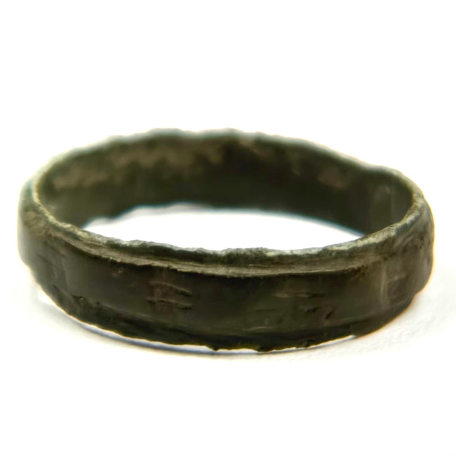 Ancient broad bronze finger band with raised rim detail and dark archaeological patina, Roman to Early Byzantine period