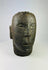 Close-up of carved facial details on a Polynesian volcanic stone ancestor effigy.