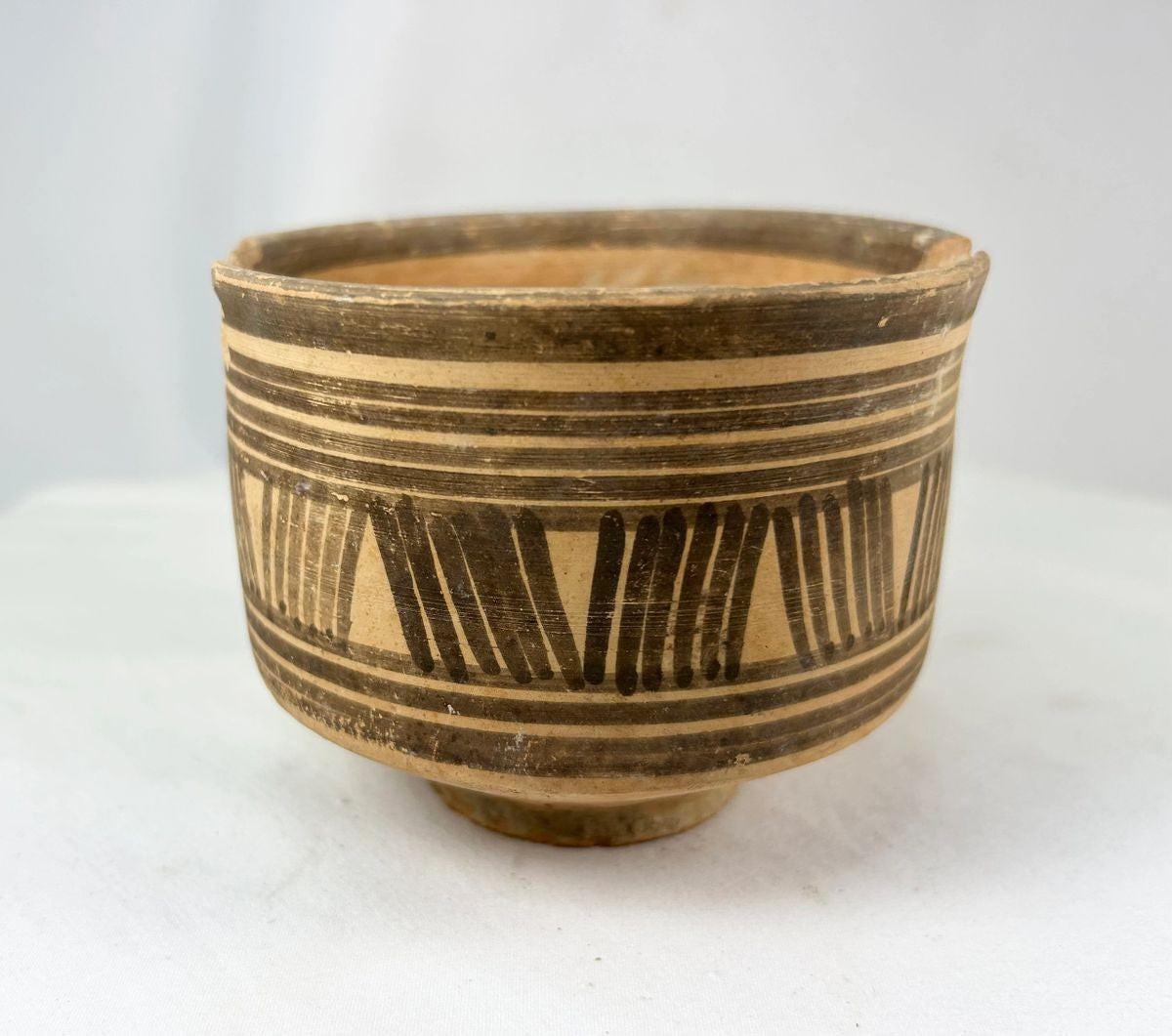 Pair of ancient Harappan terracotta pottery vessels from the Indus Valley Civilization, decorated with bold black geometric linear and zigzag motifs; hand-crafted, wide-bodied bowls with rimmed edges, dating circa 2600–1900 BCE, showing surface wear, minor chipping, and aged earthen patina consistent with archaeological finds.