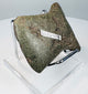 Angled view of an ancient Andean notched axe showing its rounded cutting edge, surface patina, and evidence of repeated sharpening.