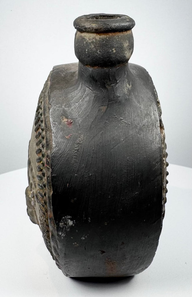Pre-Columbian ceramic flask with stepped border surrounding a modeled face