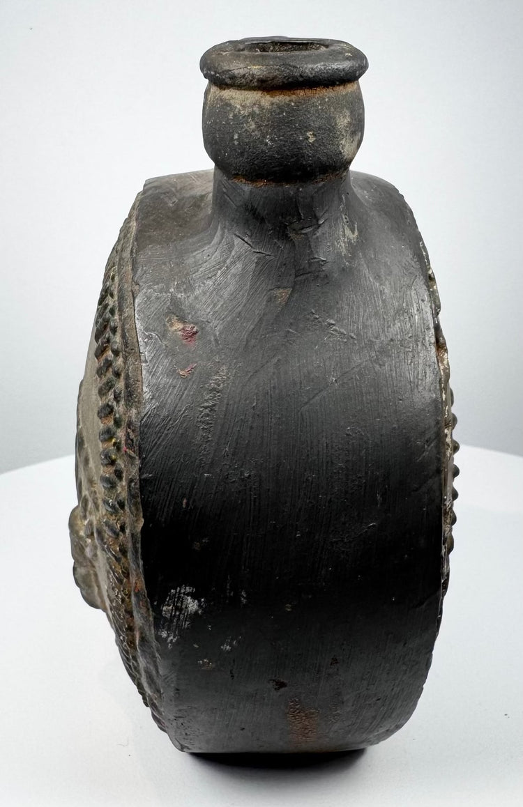 Pre-Columbian ceramic flask with stepped border surrounding a modeled face