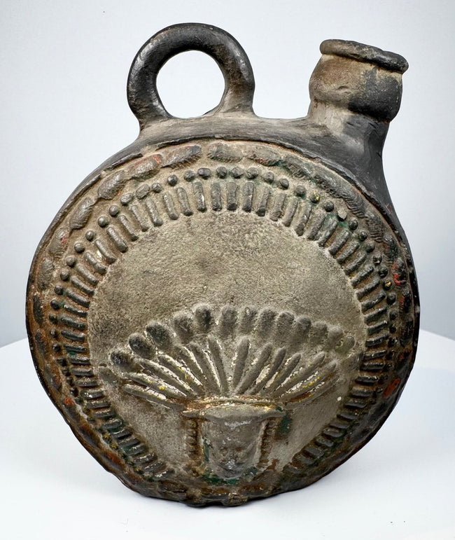 Dark-fired ceramic canteen with raised human face and feather-like ornament
