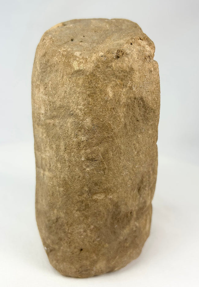 Pre-Columbian ceremonial stone figure carved from a single block, showing strong surface weathering