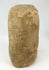 Pre-Columbian ceremonial stone figure carved from a single block, showing strong surface weathering