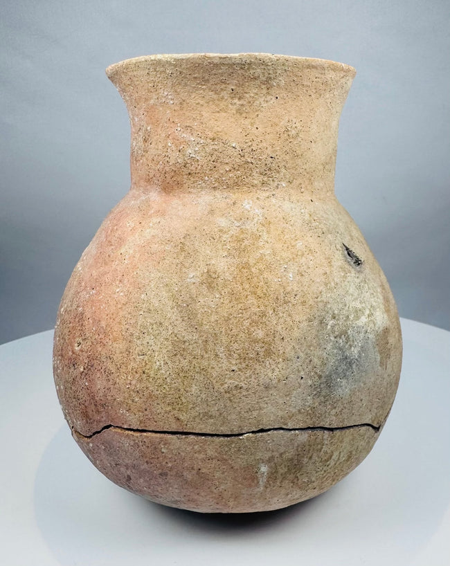 Ancient Central American ceramic storage vessel in natural buff and reddish clay tones