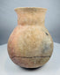 Ancient Central American ceramic storage vessel in natural buff and reddish clay tones