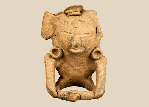 Direct frontal view of seated terracotta figure displaying symmetrical ear ornaments and broad headpiece