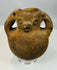 Pre-Columbian zoomorphic effigy vessel with sculpted face and dual loop handles showing heavy patina