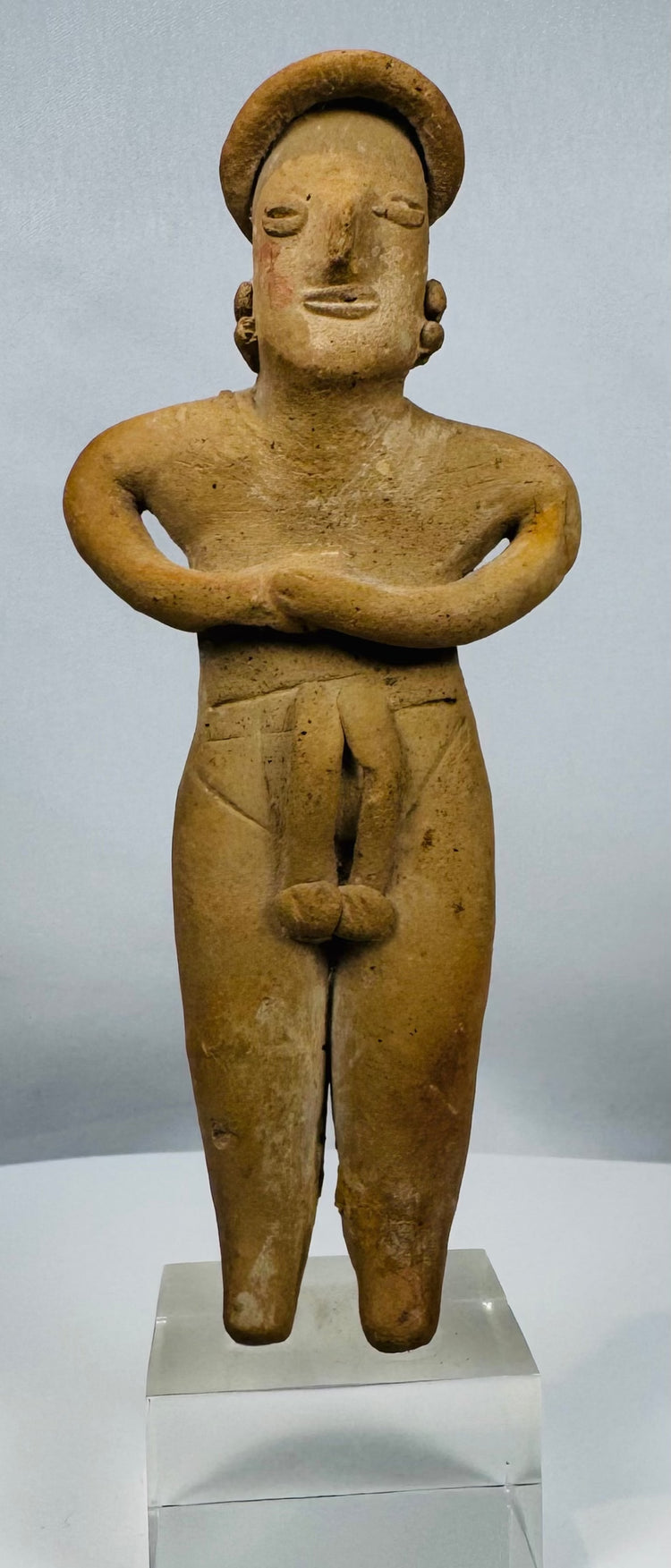 Ancient Colima female fertility figure in terracotta mounted on a lucite display stand.