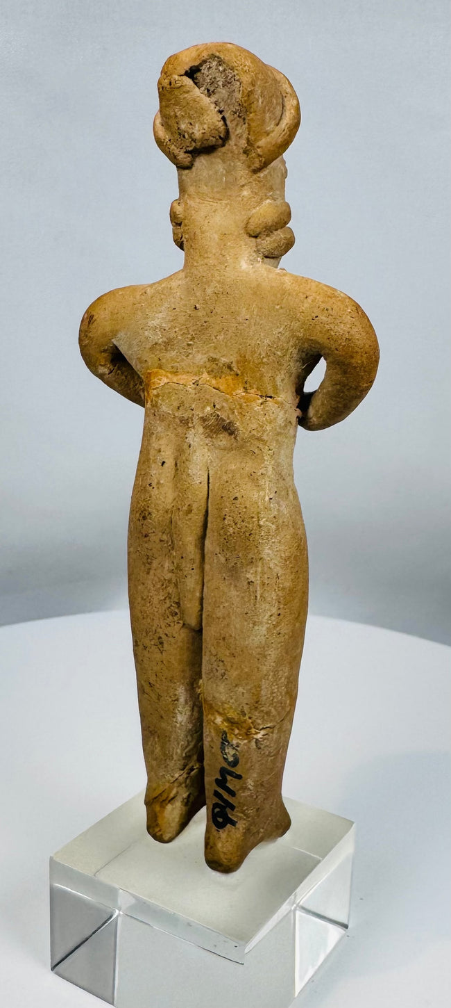 Colima gingerbread-style terracotta figure depicting a standing female with folded arms.