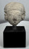 Ancient terracotta head with cranial modification and large circular ear spools from Pre-Columbian Mexico.