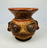 Close-up of Nicoya effigy vessel face with painted eyes, pierced ears, and mineral pigment highlights