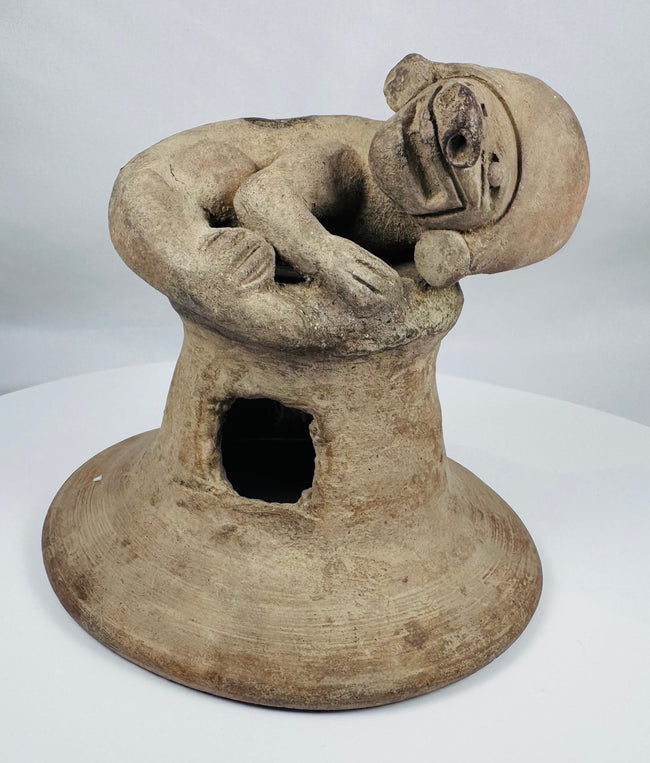 Ancient Ecuadorian terracotta incense burner lid with a sculpted anthropomorphic figure and archaeological patina.