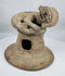 Ancient Ecuadorian terracotta incense burner lid with a sculpted anthropomorphic figure and archaeological patina.