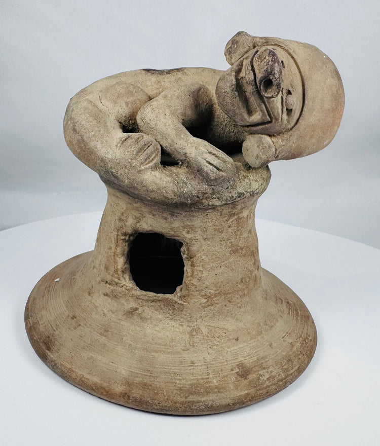 Ancient Ecuadorian terracotta incense burner lid with a sculpted anthropomorphic figure and archaeological patina.