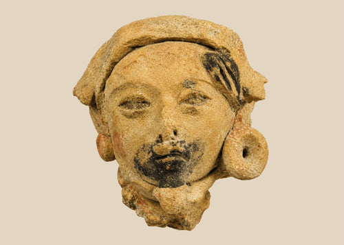 Late Classic Period Mesoamerican ceramic head fragment, circa 500–900 CE, with expressive facial features, traces of black pigment, and a detailed turban-like headpiece.