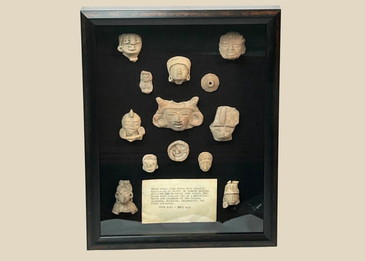 Shadowbox of 13 Pre-Columbian Mesoamerican terracotta fragments, including heads, maskettes, figurines, and spindle whorls from Teotihuacan and Veracruz traditions, 200 BCE–900 CE