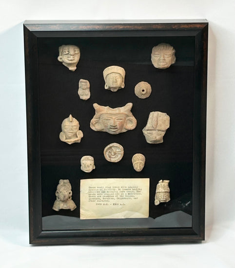 Shadowbox of 13 Pre-Columbian Mesoamerican terracotta fragments, including heads, maskettes, figurines, and spindle whorls from Teotihuacan and Veracruz traditions, 200 BCE–900 CE