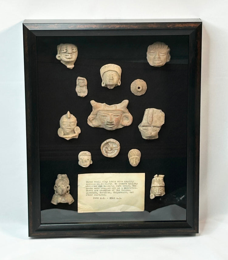 Shadowbox of 13 Pre-Columbian Mesoamerican terracotta fragments, including heads, maskettes, figurines, and spindle whorls from Teotihuacan and Veracruz traditions, 200 BCE–900 CE