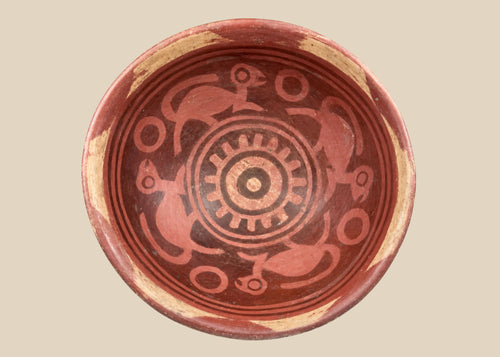 Terracotta Nariño culture bowl from Colombia and Ecuador, decorated with bichrome slip, negative resist geometric border, and four monkeys in the interior, dating from 800–1500 CE.