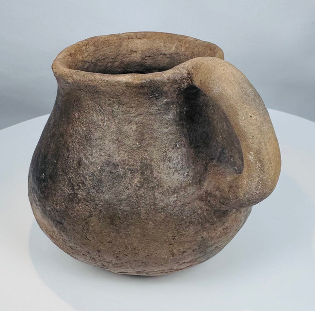 Pre-Columbian Casas Grandes ceramic vessel with rounded body, sturdy handle, and evidence of traditional indigenous pottery techniques.