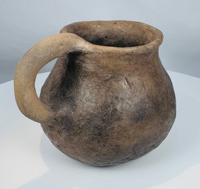 Authentic Casas Grandes earthenware mug with flared rim, globular form, and mineral deposits acquired through centuries of burial.