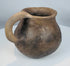 Authentic Casas Grandes earthenware mug with flared rim, globular form, and mineral deposits acquired through centuries of burial.