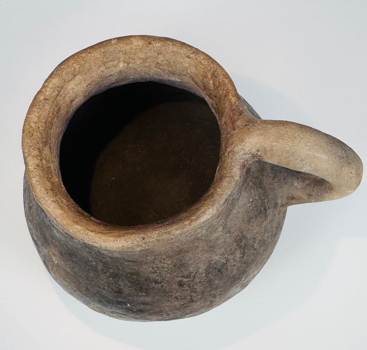 Ancient Casas Grandes utilitarian pottery vessel with natural burial patina, rounded form, and traditional ceramic construction.