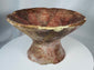 Ancient footed ceramic vessel featuring radiating triangular decoration and extensive archaeological wear.