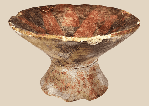 Pre-Columbian terracotta pedestal bowl with painted geometric motifs in red, cream, and dark brown pigments.