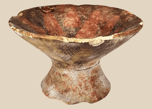 Pre-Columbian terracotta pedestal bowl with painted geometric motifs in red, cream, and dark brown pigments.
