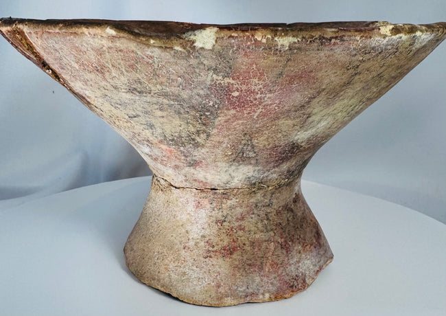 Hand-painted ancient ceramic vessel with elevated footed base and traditional geometric decoration.