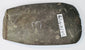 Angled view of an ancient South American ground stone axe with rounded edge from repeated sharpening and historic use.