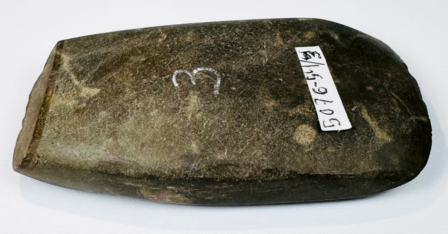 Small ancient Andean stone axe circa 200–800 AD with heavily worn edge, aged patina, and original archaeological tag.