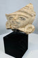 Ancient Mexican terracotta face fragment mounted for display, dating to the Late Classic–Postclassic period.