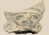 Pre-Columbian terracotta figural fragment depicting a stylized human face with large earspools and fan-shaped headdress, Mesoamerica, circa 600–1200 CE.