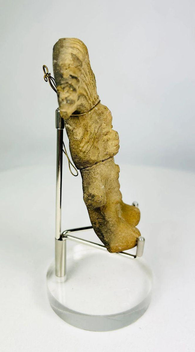 Angled view of a Pre-Columbian terracotta figurine displaying surface texture and patina