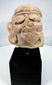 Pre-Columbian sculptural head fragment mounted on a modern display stand